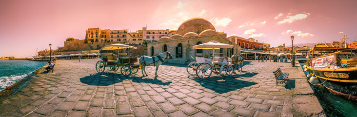 Panorama of the old harbor of Chania with horse carriages and mosque, Crete, Greece.