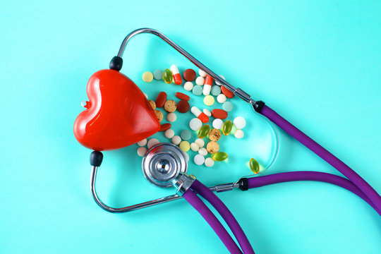 medical stethoscope with pills on a blue background