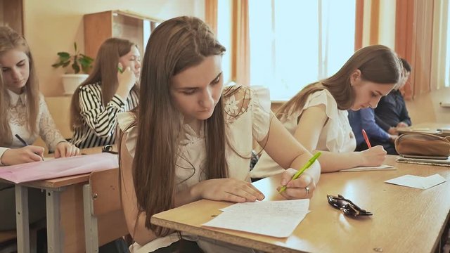 Russian school. Pupils write a control exam in their notebooks.