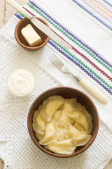 Varenyky, vareniki, pierogi, pyrohy or dumplings served with sour cream and butter.