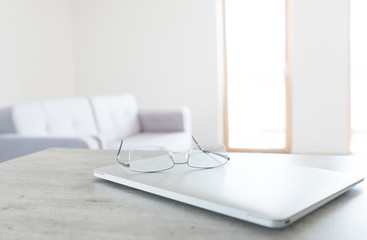 View of glasses lying on the modern laptop with scandinavian design interior