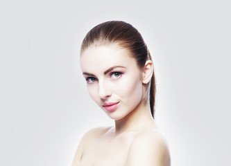 Portrait of young, beautiful and healthy woman: over cold grey background. Healthcare, spa, makeup and face lifting concept.