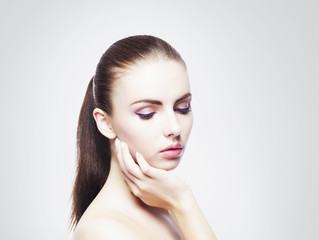 Naklejka premium Portrait of young, beautiful and healthy woman: over cold grey background. Healthcare, spa, makeup and face lifting concept.