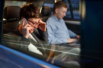 working night-business woman use smartphone in the car.