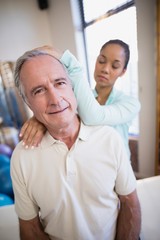 Fototapeta premium Portrait of senior male patient receiving neck massage from