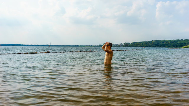 Man in water, preparing for a swim