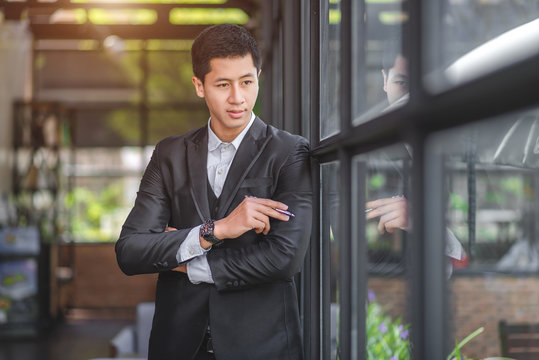 Young business man in the coffee shop. Crossed arms.