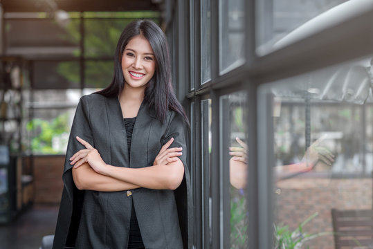 Young beautiful business woman in the coffee shop. Crossed arms.