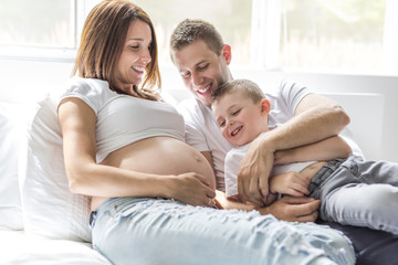 Fototapeta na wymiar father, son and pregnant mother at home. Beautiful loving family portrait