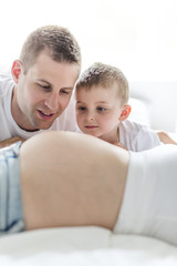 Fototapeta premium father, son and pregnant mother at home. Beautiful loving family portrait