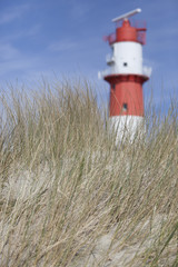 dune grass and beautiful red and white lighthouse in the background