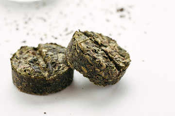 Compressed traditional chinese tea on a white background, closeup shot, selective focus