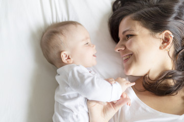 happy loving family. mother playing with her baby in the bedroom.