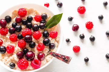 Milk oat porridge with forest berries close-up