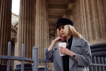 Coffee take away. Attractive blonde woman drinking coffee from a disposable Cup, outdoors