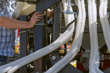Fragment of the mechanism of an agricultural machine. Workers repair equipment.