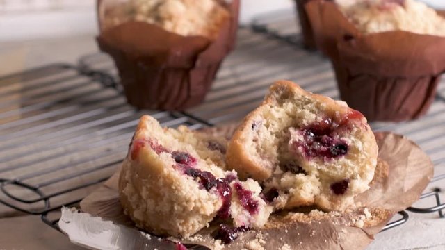 Muffins with red fruits jam fill on wooden counter top.