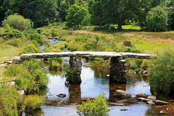 Fototapeta na wymiar Clapper Bridge in Dartmoor, an ancient public bridge over the Dart River, Devon