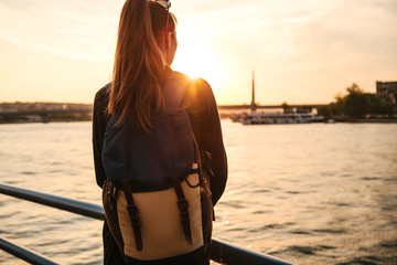 Fototapeta premium Young beautiful tourist girl with a backpack at sunset next to the Bosphorus on the background of Istanbul. Turkey. Rest, vacation, hiking.