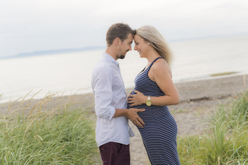 pregnant woman at beach with husband having fun