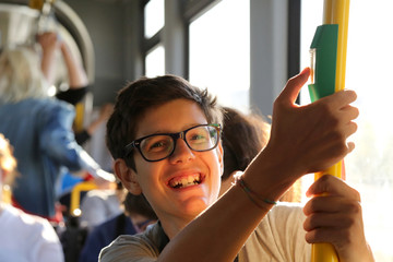 Smiling boy with stylish glasses travels by tram © ChiccoDodiFC