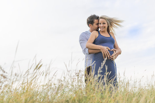 pregnant woman at beach with husband having fun