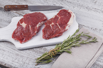 Raw fresh beef steak on a white cutting board