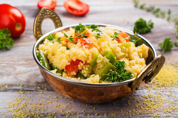 Couscouos Tabbouleh salad with tomatoes and kidney beans in a copper bowl on wooden table