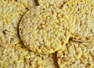 Grain crispbreads close up macro as a background.Stack of puffed whole grain crispbread.Rice cake puffed rice texture.Round rice cakes background.Corn crackers. Rice galettes.Selective focus.