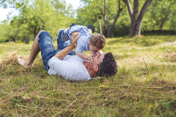 Fototapeta premium beautiful father little toddler son on the meadow.