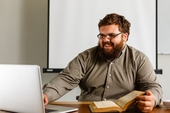 Fat teacher in glasses with laptop on white background