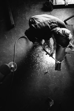 Black and white image of metal worker with cutting torch