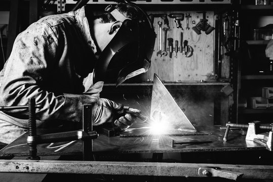 Black and white image of welder welding