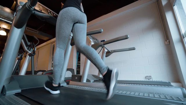 Girl runs on a treadmill in the gym