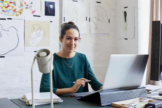 Smiling Graphic Designer At Desk In Creative Office