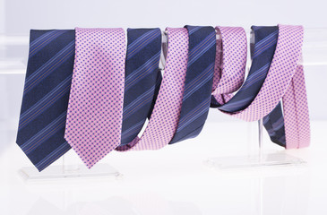 Pink and blue ties twisted around the pole. White background.