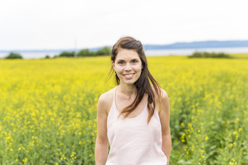 Happy young woman over yellow meadow