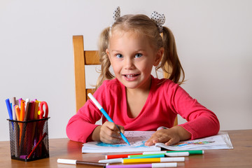 girl drawing sitting at the table