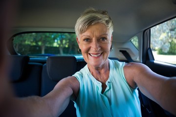 Happy senior woman inside a car