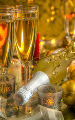 Champagne in glasses and bottle on gold background.