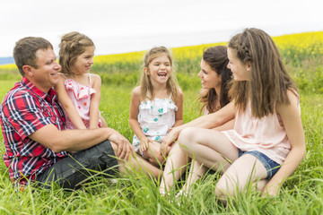 Fototapeta premium Family outdoors on a yellow field