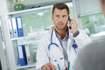 young doctor on phone at his office