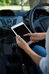 Woman using digital tablet in the car