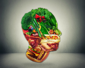 Half fast food and vegetables shaped as man face as a symbol of diet change from junk to a healthy raw vegetarian produce