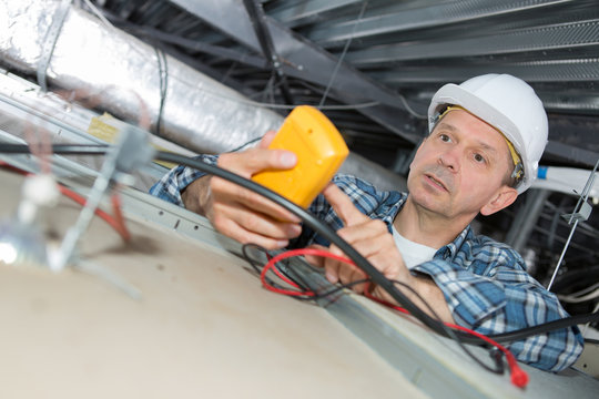 electrician repairing wiring in an office