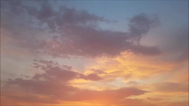 Clouds with orange, gray and black colors at sunset sky. Time-lapse motion.