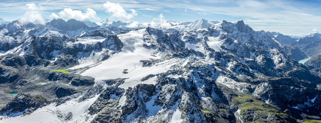 Panorama sur les montagnes vertes et enneigées des Alpes - obrazy, fototapety, plakaty