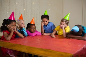 Tired children sitting at table