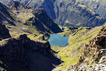 Fototapeta na wymiar vue aérienne sur des montagnes couvertes d'herbe verte avec un lac bleu au fond
