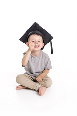 Adorable four years old child boy wearing a mortar board.